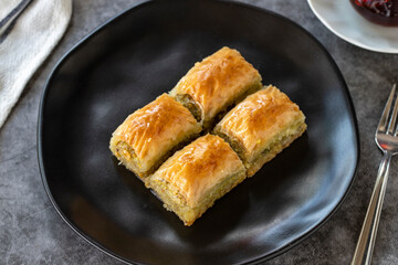 Turkish baklava. Baklava slices with pistachio on a dark background. Bakery products. side view. Turkish cuisine. Close-up.