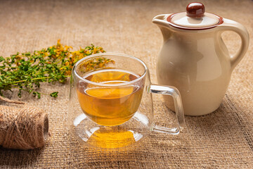 cup of herbal tea and bunch of dry hypericum on wooden table