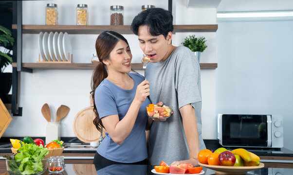 Asian Couple Cooking At Kitchen