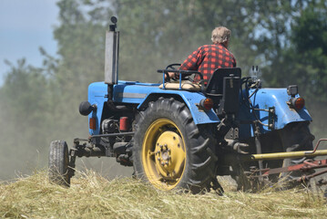 Tractor during haying works in the meadow