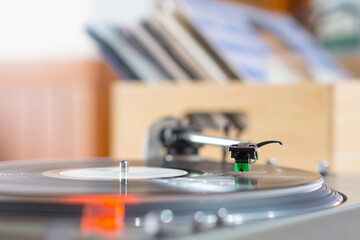 Focus on The Headshell Cartridge and Stylus of Classic Vintage Vinyl Record Player or Turntable Playing on Vinyl Record Music
