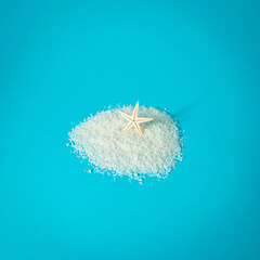 Starfish in coconut flour sand and blue background. Summer day shadow. Minimal concept.