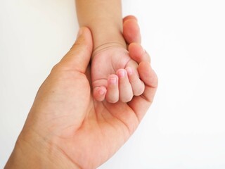 Newborn baby grasping her mother's finger. Concept of child care, feeling safe. closeup photo, blurred.