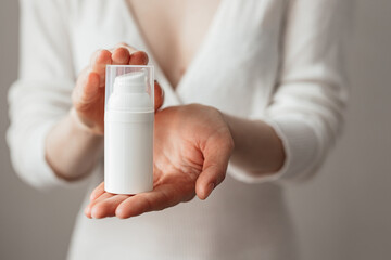 Cream skin care hands. Close-up woman holding cream for hands. Woman applying hand cream. Girl holding tube with skin care product.View from front.SPF protection.Skin healthy