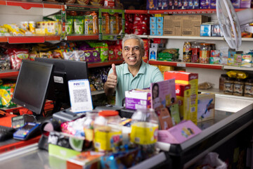Happy male cashier at supermarket - obrazy, fototapety, plakaty