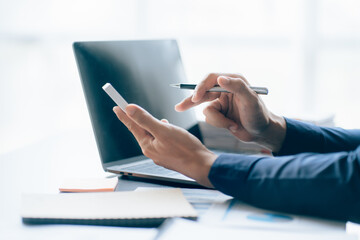 The hands of a male businessman are analyzing and calculating the annual income and expenses in a financial graph that shows results To summarize balances overall in office