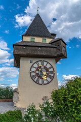 Beautiful of the clock tower on top of the Castle Hill (Schlossberg) on a sunny summer day with blue sky and cloud in background, Graz, Austria - 518771195