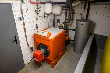 Old oil heating system with oil tank and hot water tank in the basement of a family house - heating...