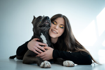 young beautiful female play with staffordshire terrier dog at hoe