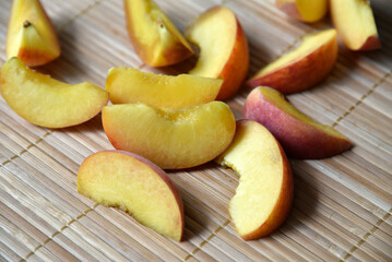 A lot of chopped apricot slices on the mat.