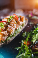 fresh sandwich with avocado, red salmon fish, arugula, tomato, salad, green