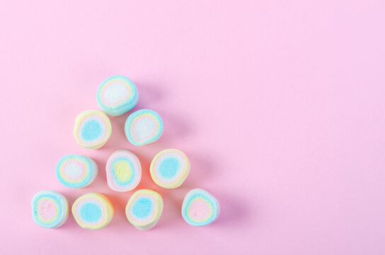 The Mini colorful marshmallows on pink background with copy space.
