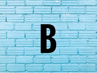 Letter B on blue brick wall