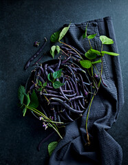 Freshly harvested purple french  beans  (dwarf, bush beans) in a black ceramic bowl. Healthy home...