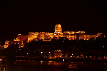 Fototapeta premium panoramic night view of the royal castle building complex in Budapest, Hungary. brightly lit palace with large stone cupola along the Danube. travel and tourism concept. European architecture. 