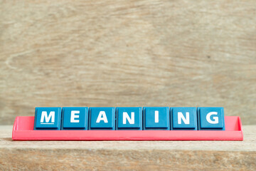 Tile alphabet letter with word meaning in red color rack on wood background