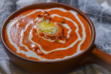 butter chicken or makhni chicken served in a dish isolated on dark background side view.
