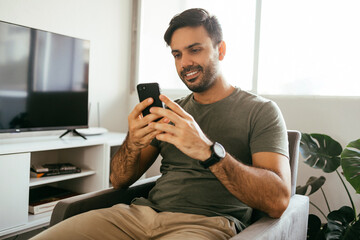 Young man using cellphone in the living room
