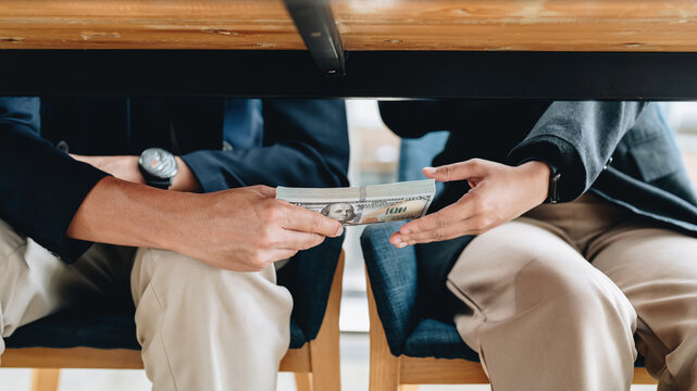 Hands Passing Money Under Table Corruption Bribery Concept