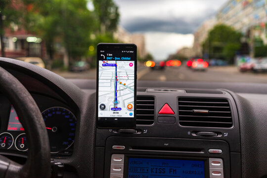 Using waze maps application on smartphone on car dashboard, Bucharest, Romania, 2022