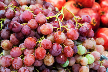 Clusters of red grapes on the counter in the store. Trade in sweet fruits and berries. Close-up