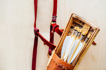 Arrows and quiver on a wooden background. Medieval weapons according to ancient traditions....