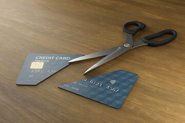 Scissors cut a credit card into halves on a wooden table. Illustration of the concept of avoiding credit card traps and debt