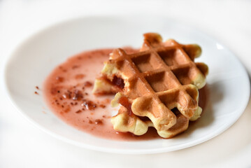 Viennese waffles with jam on a white plate. Delicious sweet breakfast with waffle.