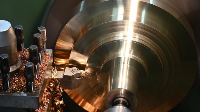 The pan scene of lathe machine finish cutting the brass disk parts by lathe tools.