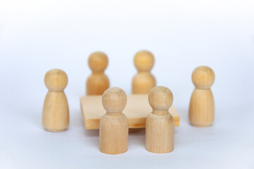 Wooden people figures having business meeting with customizable spare for text or ideas.