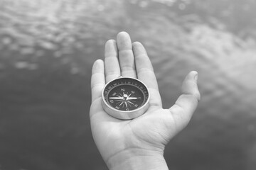 Old classic navigation compass in hand on natural background