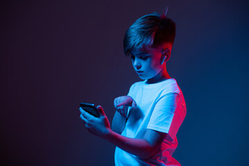 Boy with a phone in his hands in neon light
