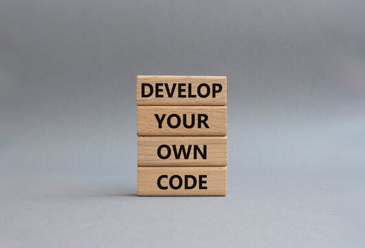 Develop your own code symbol. Concept words Develop your own code on wooden blocks. Beautiful grey background. Business and Develop your own code concept. Copy space.