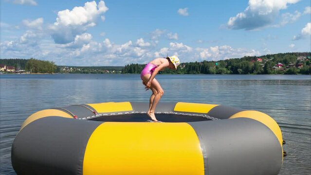 girl jumps on water inflatable trampoline