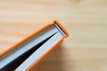 detail of a hardcover book covered in orange cloth