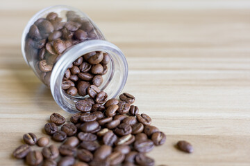 top view of coffee beans on wooden table with glass bottle