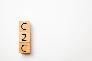 個人間取引。C2C。Consumer to Consumer。木製のブロックに描かれているB2Cの文字。木製のテーブルの背景。