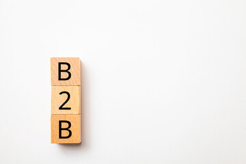 企業間取引。B2B。Business to Business。木製のブロックに描かれているB2Bの文字。木製のテーブルの背景。