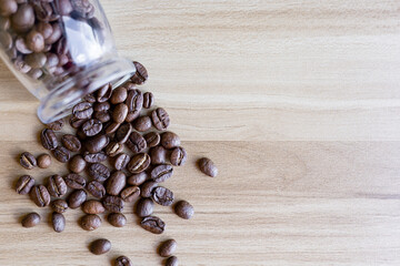 top view of coffee beans on wooden table with glass bottle