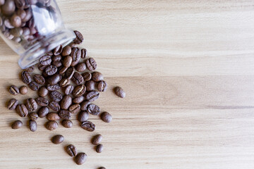 top view of coffee beans on wooden table with glass bottle