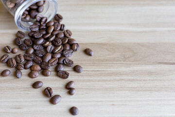 top view of coffee beans on wooden table with glass bottle