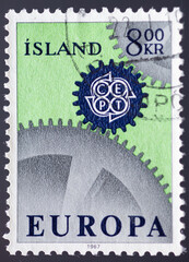 ICELAND - CIRCA 1967: a postage stamp from ICELAND , showing a gears meshing with the emblem of the CEPT. Text : EUROPE. Circa 1967