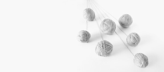 balls of grey yarn unwinding from a perspective, on an isolated white background
