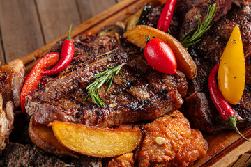 Closeup on assorted grilled meat set on wooden serving board