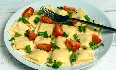 four cheese ravioli with tomatoe green onions and parsley
