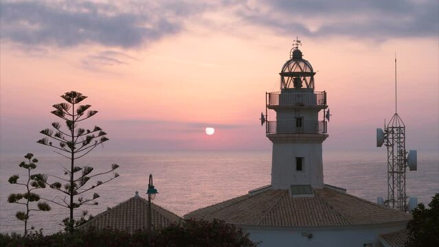 Time lapse, sunrise over the lighthouse, in Cullera, Valencia Spain.