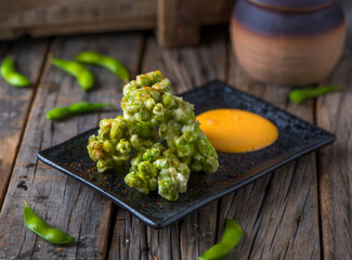 tempura edimame or tempura edamame served in a dish isolated on wooden background side view of appetizer