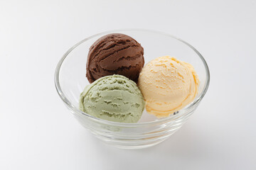 Three scoops of ice cream, chocolate,vanilla,green tea ice cream in a glass bowl on white background.