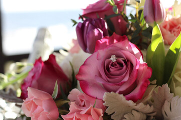 bouquet of pink roses with engagement ring and champagne