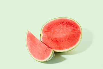 Cut watermelon on green pastel background